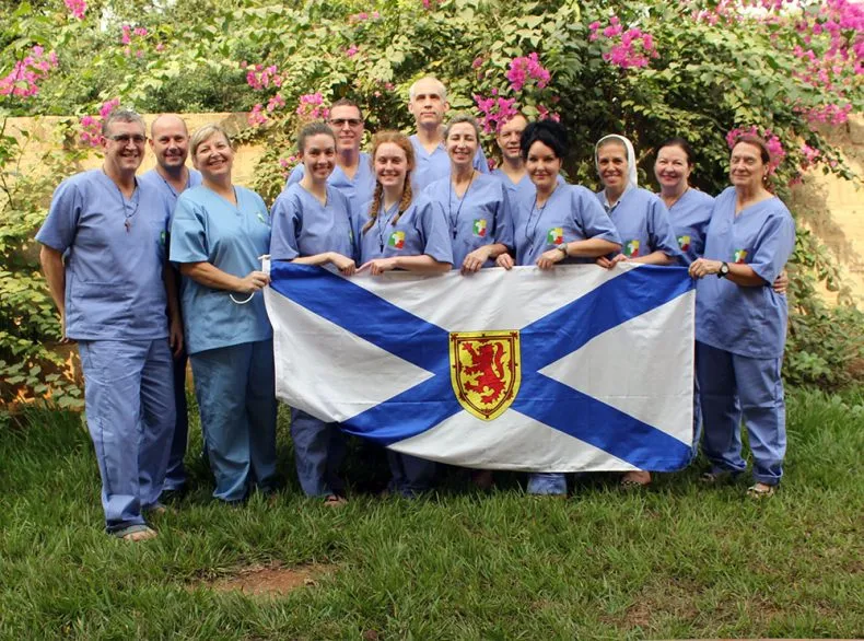 Group photo of Bourget Foundation doctors and staff holding banner